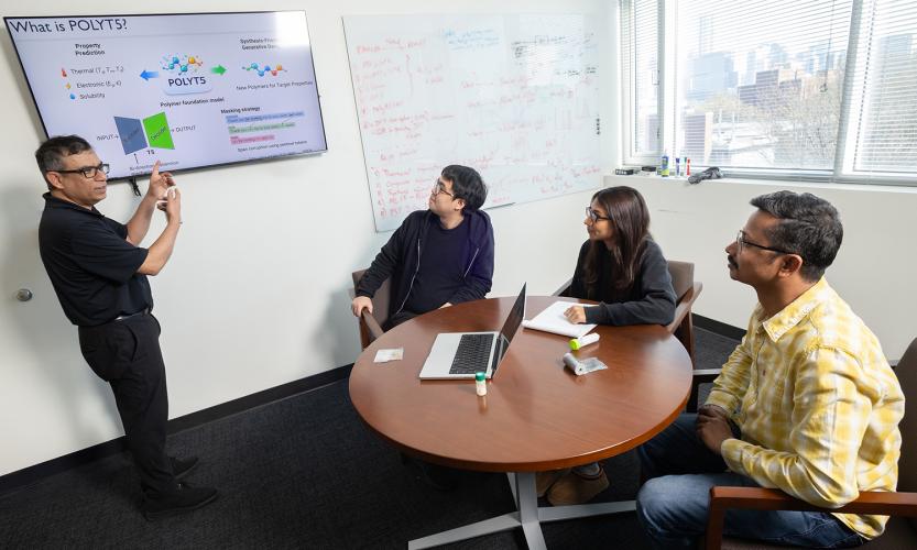 Rampi Ramprasad and three members of his research team discuss their AI model for generative polymer design in his office.